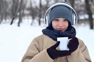 giovane ragazza con cuffie e caffè tazza foto