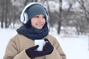 giovane ragazza con cuffie e caffè tazza foto