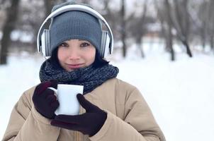 giovane ragazza con cuffie e caffè tazza foto