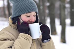 inverno ritratto di giovane ragazza con smartphone e caffè tazza foto