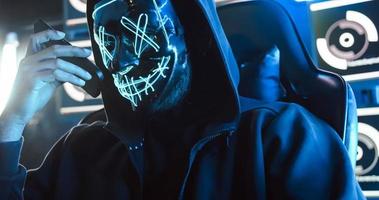 un' pirata indossare un' maschera per copertina il suo viso è utilizzando computer per mod dati per ottenere riscatto a partire dal vittime. foto