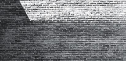 mattone parete con ombra per sfondo nel nero e bianca tono. arte e modello sfondo nel monocromatico stile. soppalco, ruvido e grunge esterno o interno design con copia spazio foto