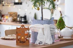 chiave per il Casa su accogliente casa con Natale arredamento su tavolo di festivo cucina. regalo per nuovo anno. costruzione, disegno, progetto, in movimento per nuovo Casa, mutuo, affitto e Acquista vero tenuta foto