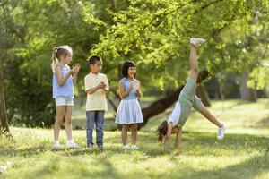 gruppo di asiatico e caucasico bambini avendo divertimento nel il parco foto