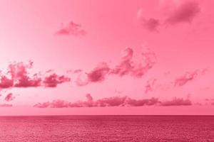 bello paesaggio marino con cumulo nuvole sopra mare superficie. Immagine tonica nel colore di il anno 2023 Viva magenta. foto