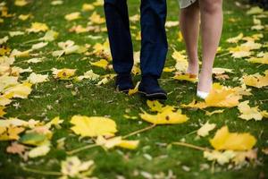 piedi di sposa e sposo . il sposa e sposo Tenere su mani e a piedi su strada nel il natura. all'aperto. giù Visualizza a scarpe. foto