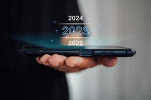 benvenuto anno 2023. nuovo anno 2022 modificare per 2023 concetto, uomo d'affari mano toccante su 2023 virtuale schermo. foto