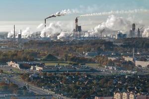 ariel panoramico Visualizza di città con enorme fabbrica con fumo camini nel il sfondo foto