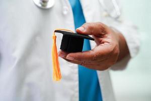 donna asiatica medico che tiene il cappello di laurea in ospedale, concetto di educazione medica. foto