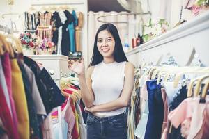 ritratto di un' bellissimo donna nel un' camicia Tenere sua credito carta foto