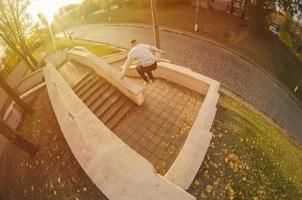 un' giovane tipo esegue un' saltare attraverso il spazio fra il calcestruzzo parapetti. il atleta pratiche parkour, formazione nel strada condizioni. il concetto di gli sport sottoculture tra gioventù foto