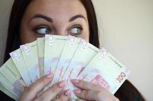 brunetta caucasico ragazza ritratto con grande quantità di ucraino i soldi foto