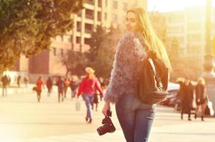 posteriore Visualizza di un' ragazza con un' digitale telecamera su un' affollato strada ba foto