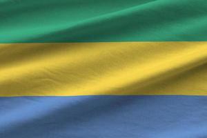 Gabon bandiera con grande pieghe agitando vicino su sotto il studio leggero al chiuso. il ufficiale simboli e colori nel bandiera foto