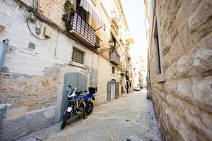 motociclo in piedi a il vuoto strada di vecchio italiano cittadina Bari, pugliese, Sud Italia. foto