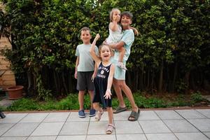 quattro contento bambini su il terrazza di il Casa. fratelli e sorelle. foto