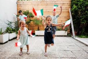 contento quattro bambini con italiano bandiere festeggiare repubblica giorno di Italia. foto