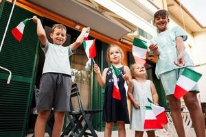 contento quattro bambini con italiano bandiere festeggiare repubblica giorno di Italia. foto