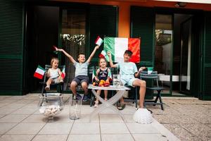 contento quattro bambini con italiano bandiere festeggiare repubblica giorno di Italia. foto