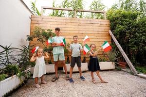 contento quattro bambini con italiano bandiere festeggiare repubblica giorno di Italia. foto