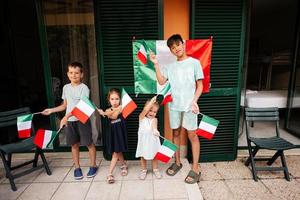 contento quattro bambini con italiano bandiere festeggiare repubblica giorno di Italia. foto