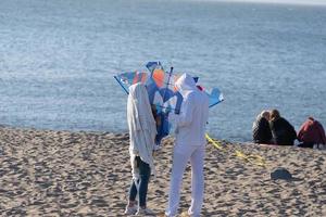 adulti fabbricazione un' aquilone su un' spiaggia foto