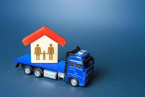 il camion trasporti il Casa con il famiglia. casa in movimento trasporto azienda. delocalizzazione per opera. mobilità e flessibilità di lavoratori. migrazione di umano risorse, lavoro duro e faticoso masse. foto