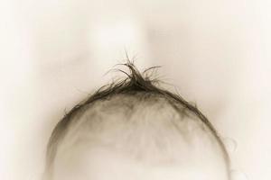 neonato bambino capelli chiudere. nero e bianca foto