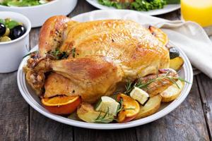 pollo intero arrosto sul tavolo da pranzo foto