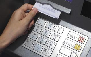 ATM pulsante vicino su e carta transazione depositare pagare scivolare e mano. foto