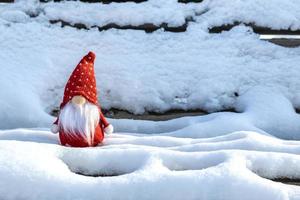 Natale vacanza carta carino scandinavo gnomi con rosso cappello e bianca barba su nevoso inverno panchina fiaba nevicata orario invernale Ciao dicembre, gennaio, febbraio concetto contento nuovo anno, Natale foto