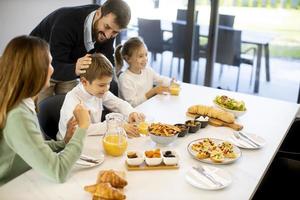 giovane contento famiglia parlando mentre avendo prima colazione a cenare tavolo foto