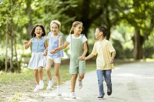 gruppo di asiatico e caucasico bambini avendo divertimento nel il parco foto