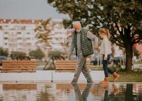 nonno la spesa tempo con il suo nipotina di piccolo acqua piscina nel parco su autunno giorno foto