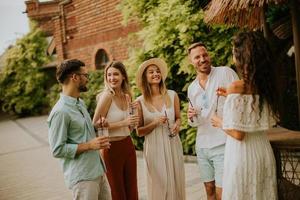 gruppo di giovane persone applauso e avendo divertimento all'aperto con bevande foto