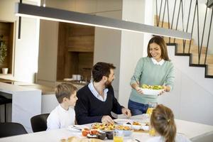 giovane madre preparazione prima colazione per sua famiglia nel il cucina foto