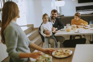 giovane madre preparazione prima colazione per sua famiglia nel il cucina foto