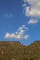 nuvole piace barboncino cani galleggiante nel il aria nel il chiaro cielo e caldo luce del sole durante il giorno e il circostante montagne siamo completo. foto