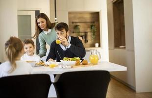 giovane madre preparazione prima colazione per sua famiglia nel il cucina foto