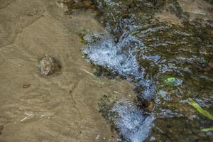 sfondo con pietre di il fiume e acqua. prendere un' camminare nel il parco su un' estate giorno e ammirare il bellissimo scenario. selettivo messa a fuoco, sfondo. foto