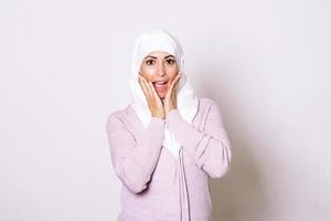 bellissimo musulmano donna indossare hijab festeggiare per bene notizia. bellissimo giovane musulmano donna indossare un' hijab su sua testa foto