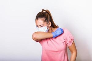 donna tosse nel gomito con chirurgico viso maschera protezione. freddo, influenza, virus, tonsillite, acuto respiratorio patologia, quarantena, epidemico. covid - 19, coronavirus prevenzione foto