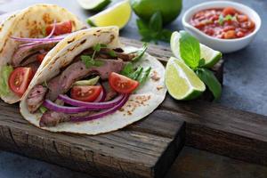 bistecca tacos con affettato incontrare, insalata e pomodoro salsa foto