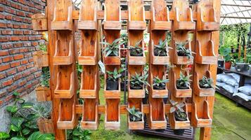 di legno pianta cremagliera con molte di scaffali per mettere il tuo pentole all'aperto. verticale giardino. foto