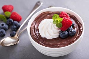 cioccolato budino con frustato crema e frutti di bosco foto