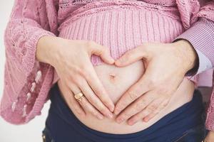 incinta donna con un' cuore a il stomaco foto