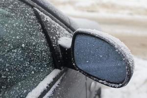 specchio auto coperto con neve foto