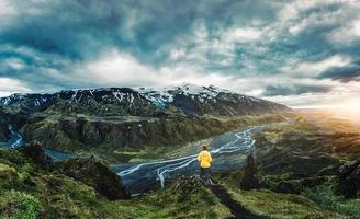 scenario di escursionista in piedi su superiore di valahukur punto di vista tra il montagna e fiume nel islandese Highlands foto