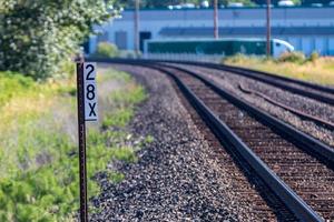 Ferrovia brani e cartello con edificio nel il distanza foto