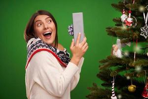 adulto contento donna con Natale regalo al di sopra di verde sfondo foto
